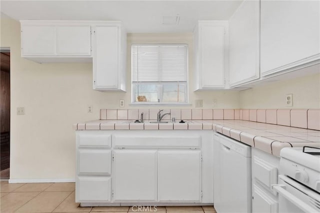 kitchen with tile counters, white appliances, white cabinets, and a sink