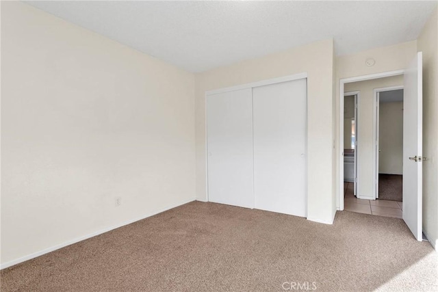 unfurnished bedroom with a closet and carpet flooring