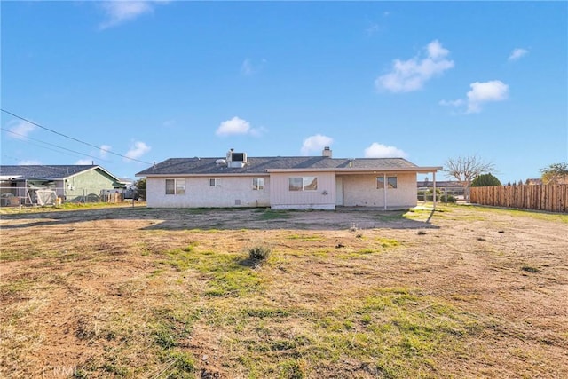 rear view of property featuring fence