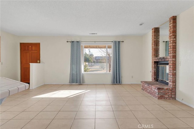 unfurnished living room featuring light tile patterned floors, baseboards, visible vents, a textured ceiling, and a fireplace