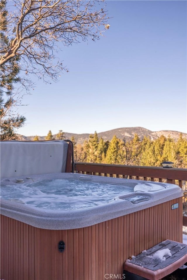 exterior space with a mountain view and a hot tub