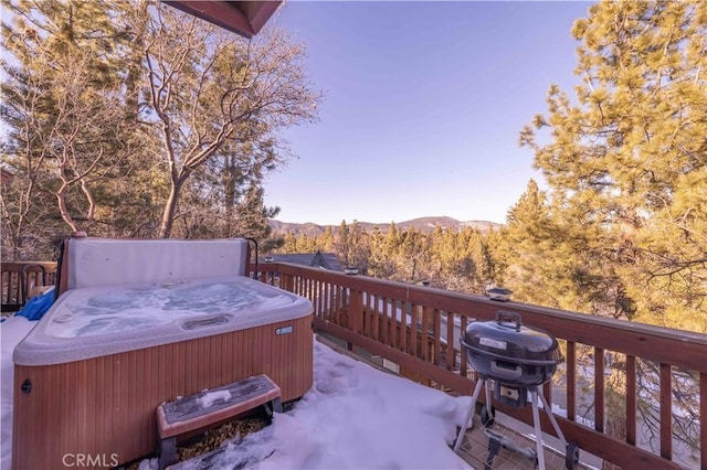 deck with grilling area, a mountain view, and a hot tub