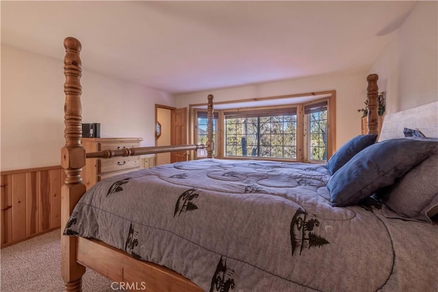 carpeted bedroom with wooden walls and wainscoting