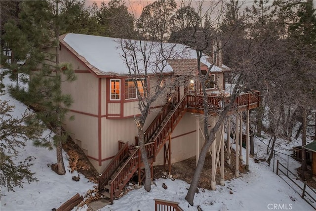 exterior space featuring a deck, a shingled roof, and stairway