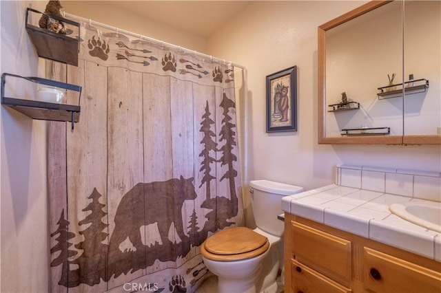 bathroom with toilet, curtained shower, and vanity