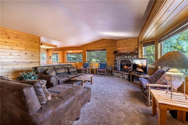 living area with vaulted ceiling, carpet flooring, wood walls, and a healthy amount of sunlight