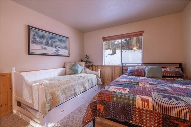 bedroom featuring carpet flooring and wooden walls