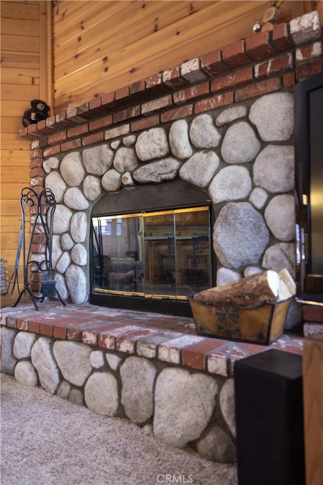 interior details with a stone fireplace and wood walls