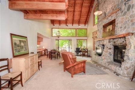 living area featuring carpet floors, beamed ceiling, a fireplace, and wood ceiling