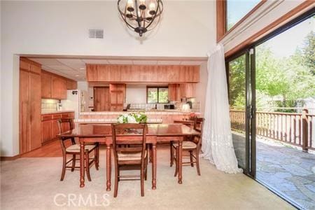 dining area featuring an inviting chandelier, a high ceiling, and visible vents