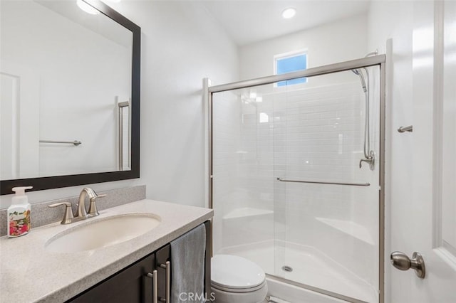 full bath featuring toilet, a stall shower, and vanity