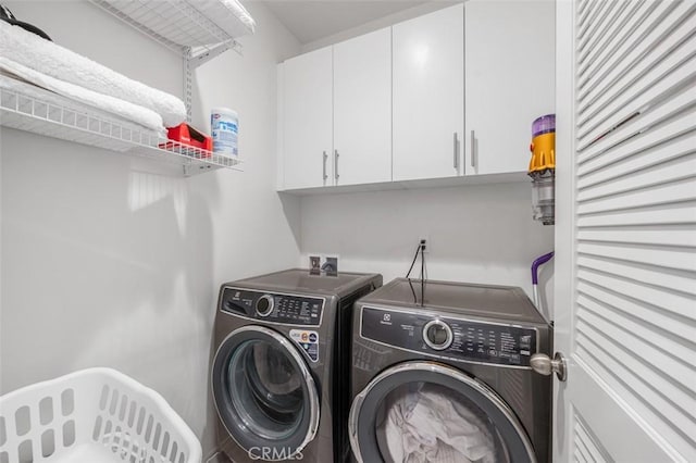 laundry area featuring cabinet space and washing machine and clothes dryer