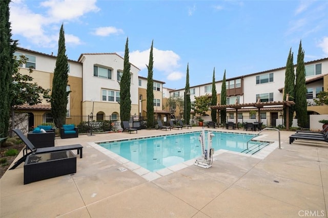 community pool featuring a residential view, fence, and a patio