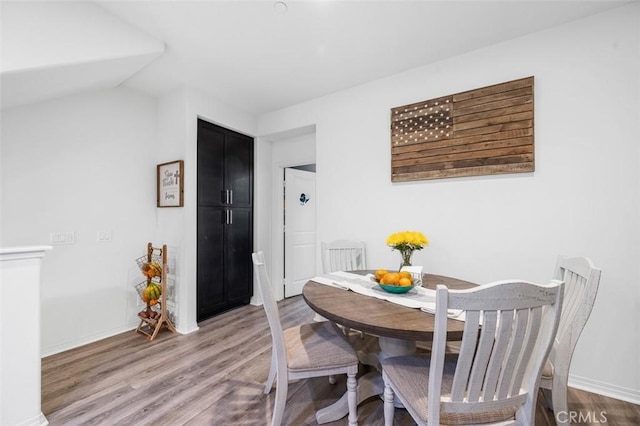 dining space with baseboards and wood finished floors