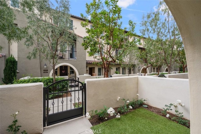 view of front of house featuring a fenced front yard, a gate, and stucco siding