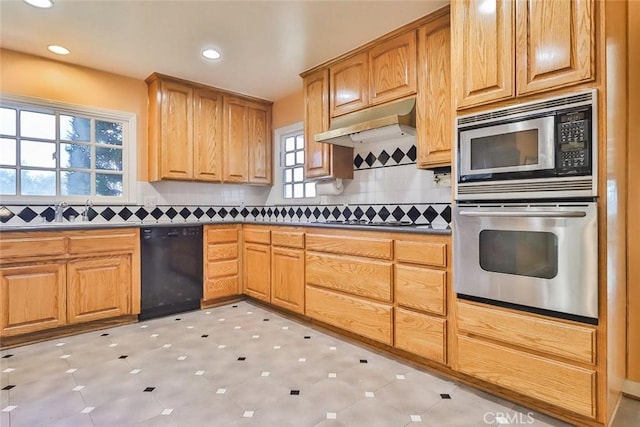 kitchen featuring tasteful backsplash, dark countertops, under cabinet range hood, recessed lighting, and appliances with stainless steel finishes