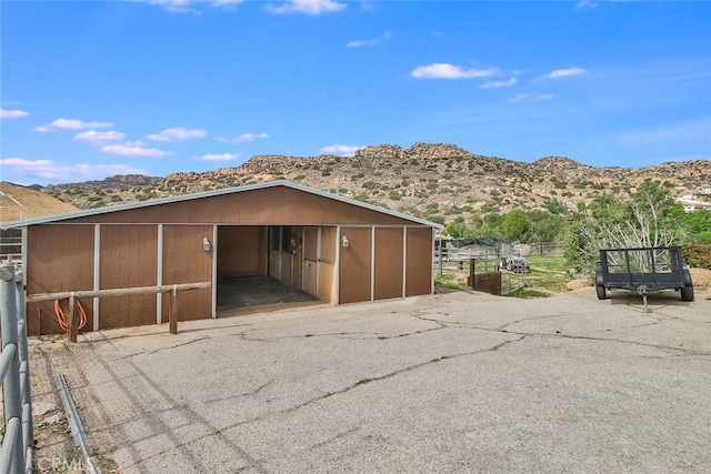 view of outdoor structure with an outbuilding, a carport, a mountain view, and an exterior structure