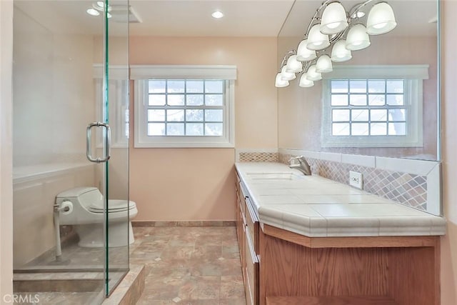 bathroom featuring decorative backsplash, a notable chandelier, a stall shower, and a wealth of natural light