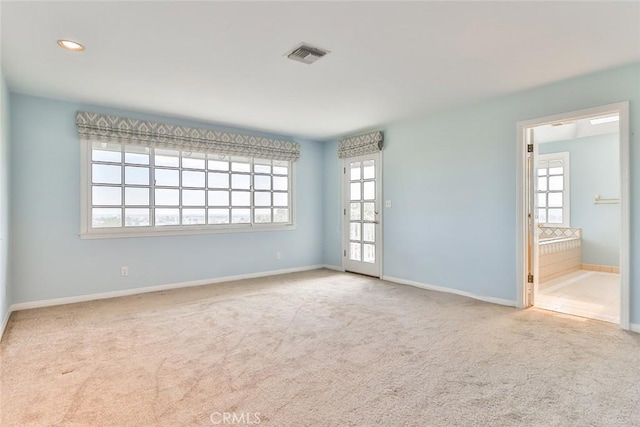 carpeted spare room featuring recessed lighting, visible vents, and baseboards