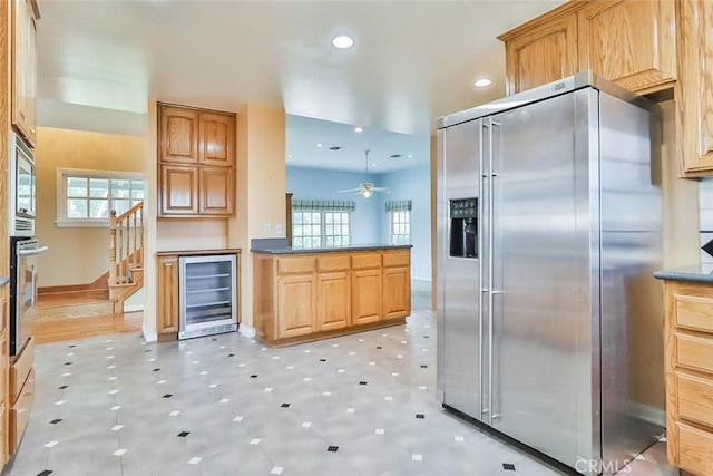 kitchen with beverage cooler, recessed lighting, stainless steel appliances, a peninsula, and baseboards