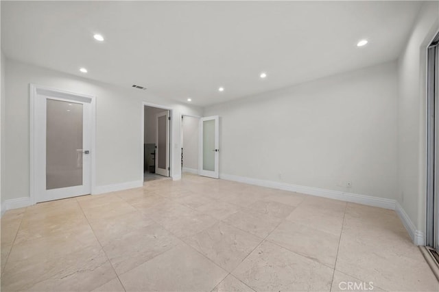 empty room with recessed lighting, visible vents, and baseboards