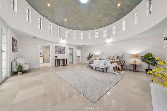 bedroom with a high ceiling and baseboards