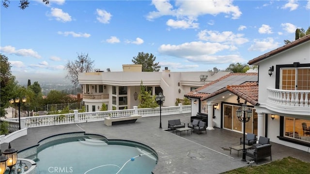 rear view of property with fence, a tile roof, a fenced in pool, stucco siding, and a patio area