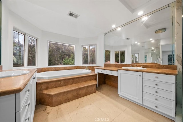 full bathroom with a sink, a garden tub, visible vents, and two vanities