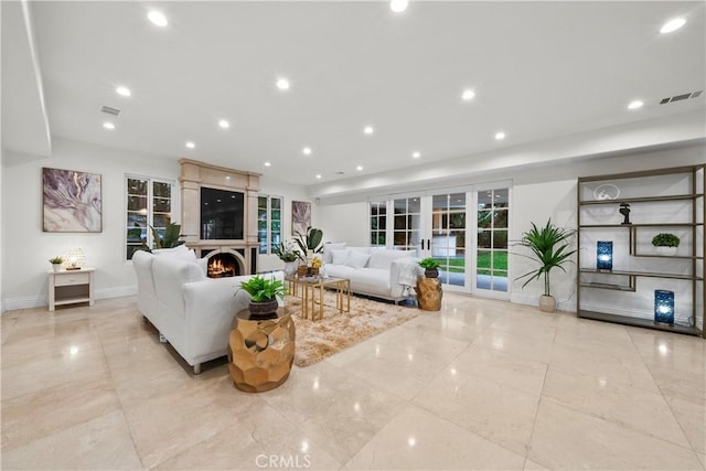 living room with baseboards, visible vents, a lit fireplace, french doors, and recessed lighting