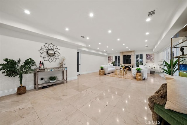 living room featuring marble finish floor, a fireplace, baseboards, and recessed lighting