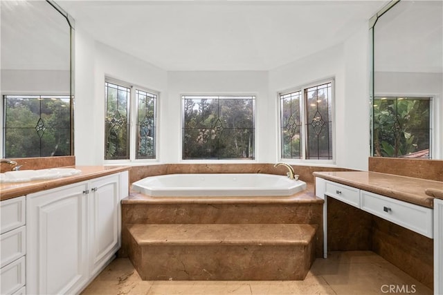 bathroom with a healthy amount of sunlight, a bath, and vanity