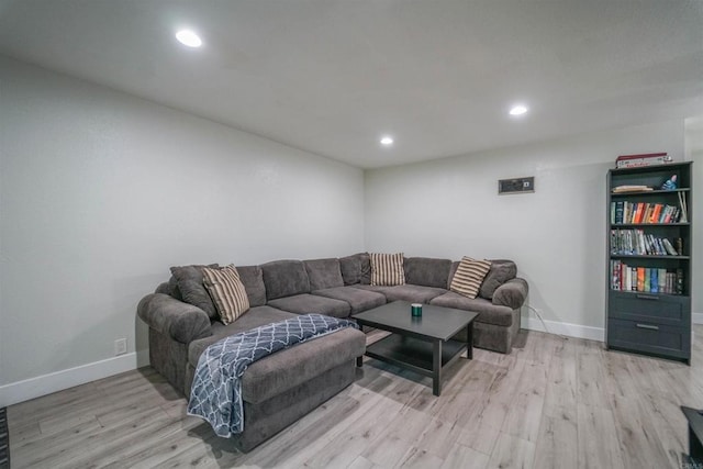 living room featuring light wood-type flooring, baseboards, and recessed lighting