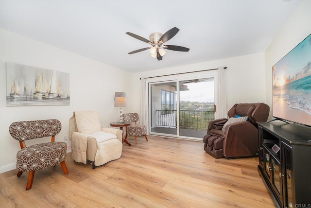 sitting room featuring baseboards, light wood finished floors, and ceiling fan