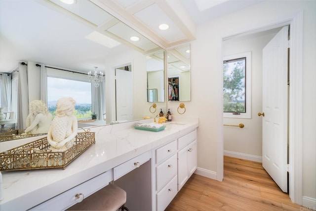 bathroom with baseboards, double vanity, recessed lighting, wood finished floors, and a sink