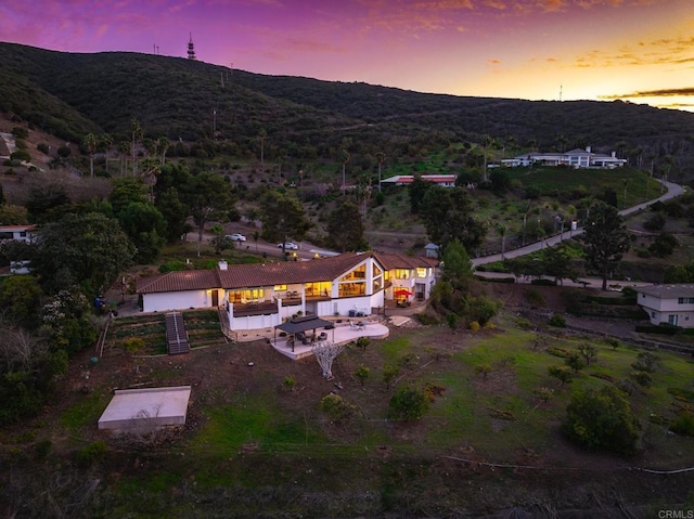 aerial view at dusk featuring a mountain view