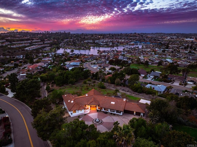 aerial view at dusk featuring a water view