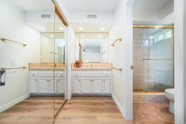 full bath featuring visible vents, a shower stall, vanity, and wood finished floors