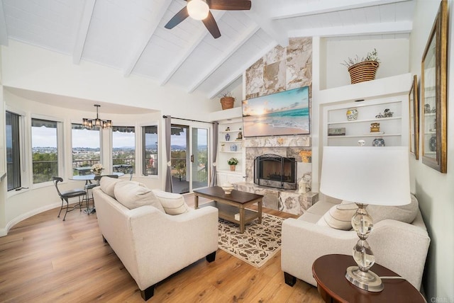 living area featuring a fireplace, beamed ceiling, built in shelves, and wood finished floors