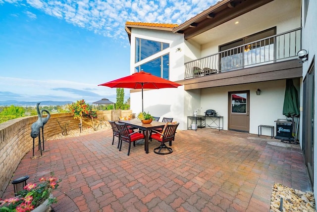 view of patio / terrace with a fenced backyard, outdoor dining space, and a balcony