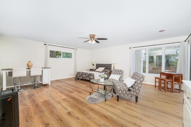 bedroom featuring light wood-type flooring, multiple windows, and baseboards