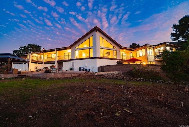 back of property at dusk with central AC