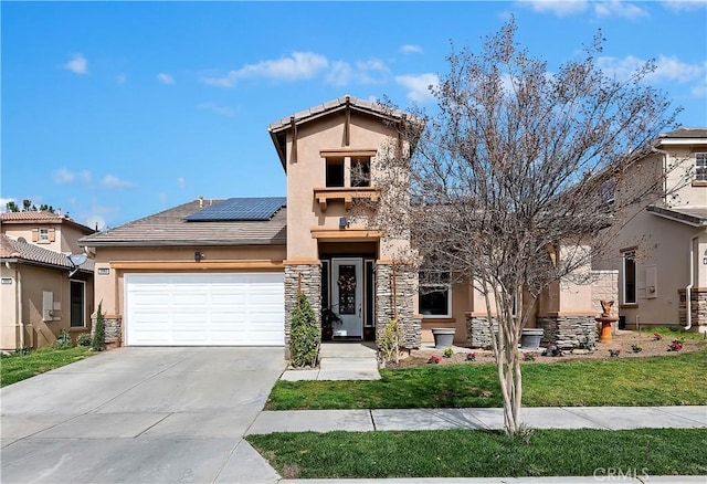 view of front facade featuring a garage, driveway, stone siding, roof mounted solar panels, and stucco siding