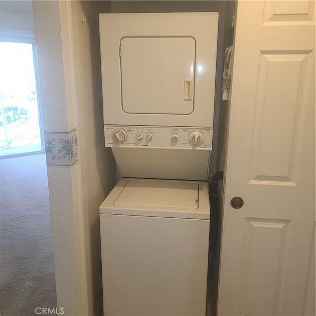 washroom featuring carpet, laundry area, and stacked washing maching and dryer