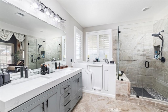 full bathroom featuring a garden tub, a sink, a shower stall, and double vanity