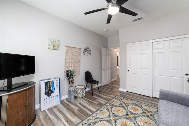 interior space with visible vents, ceiling fan, baseboards, and wood finished floors