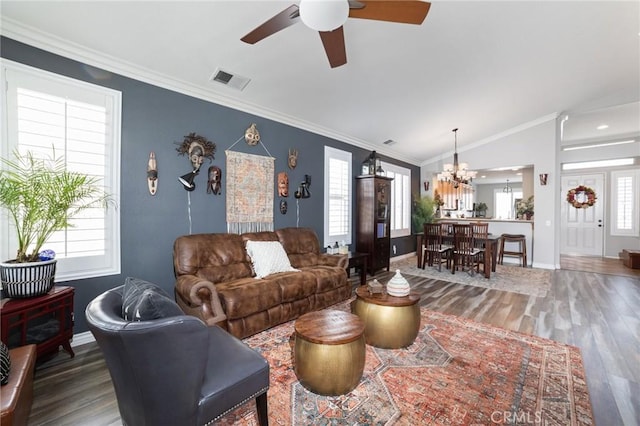 living area with visible vents, vaulted ceiling, crown molding, and wood finished floors