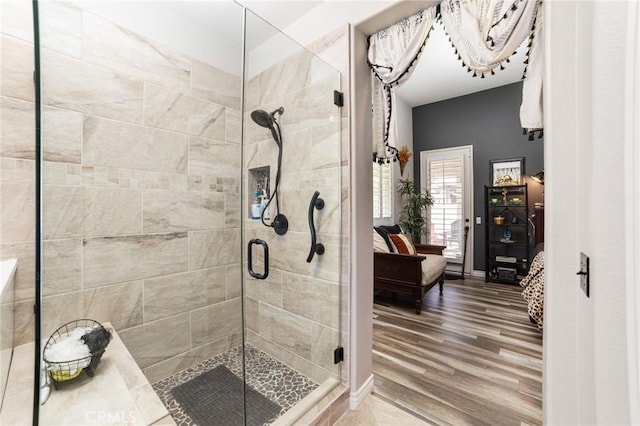 ensuite bathroom with ensuite bath, wood finished floors, and a shower stall