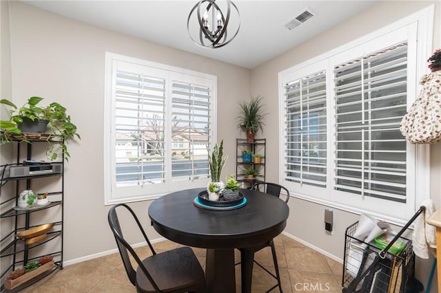 dining room featuring a chandelier, light tile patterned flooring, visible vents, and baseboards