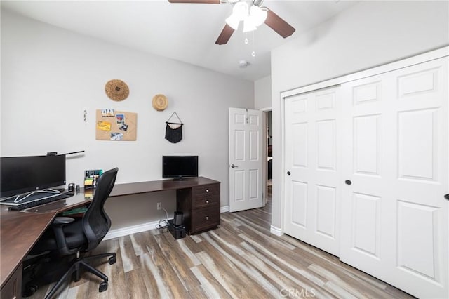 home office featuring ceiling fan, light wood finished floors, and baseboards