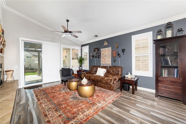 living area with a healthy amount of sunlight, a fireplace, vaulted ceiling, and wood finished floors